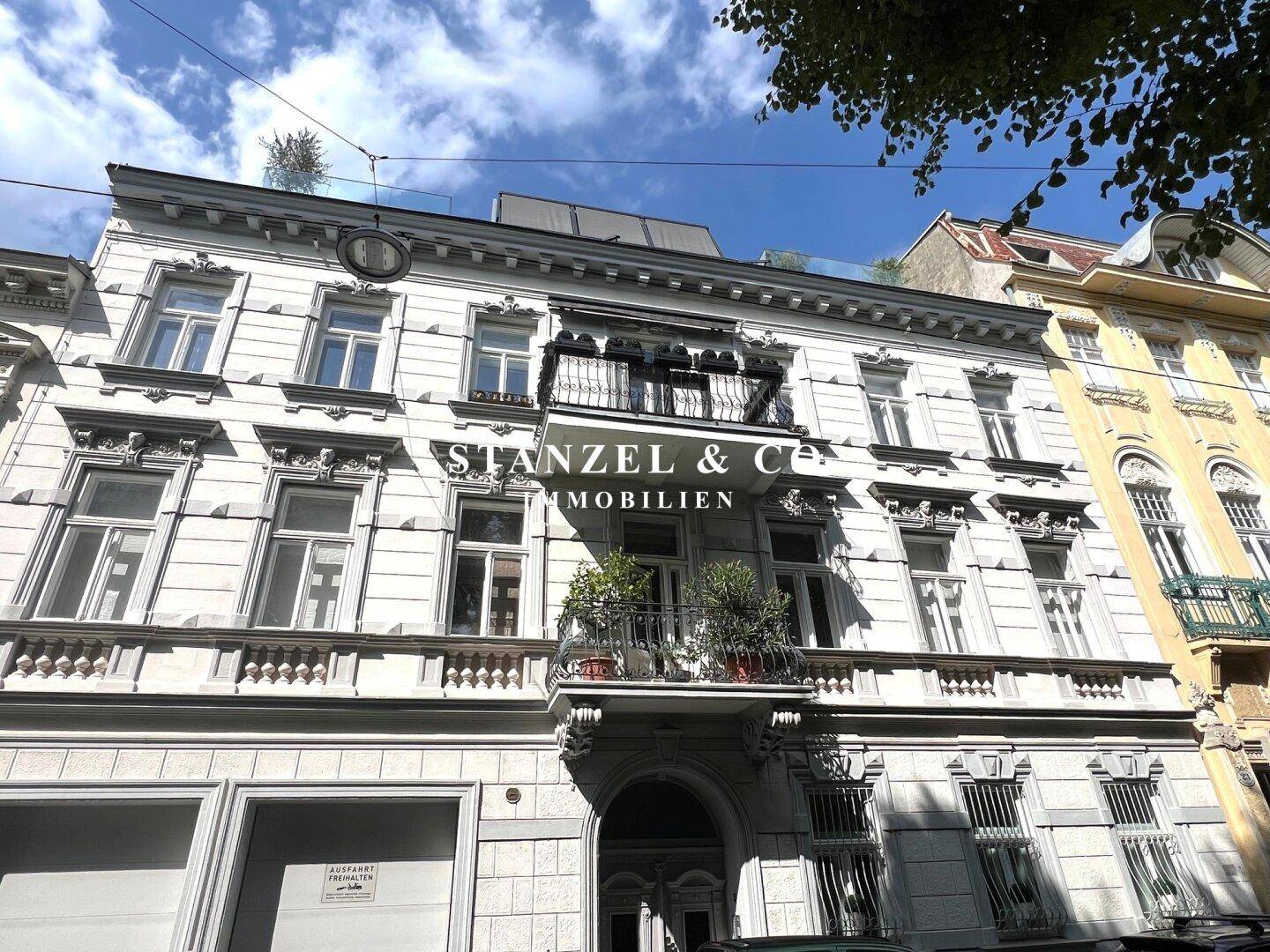 Historische Fassade eines Wohngebäudes mit mehreren Balkonen und dekorativen Elementen in der Stadt.
