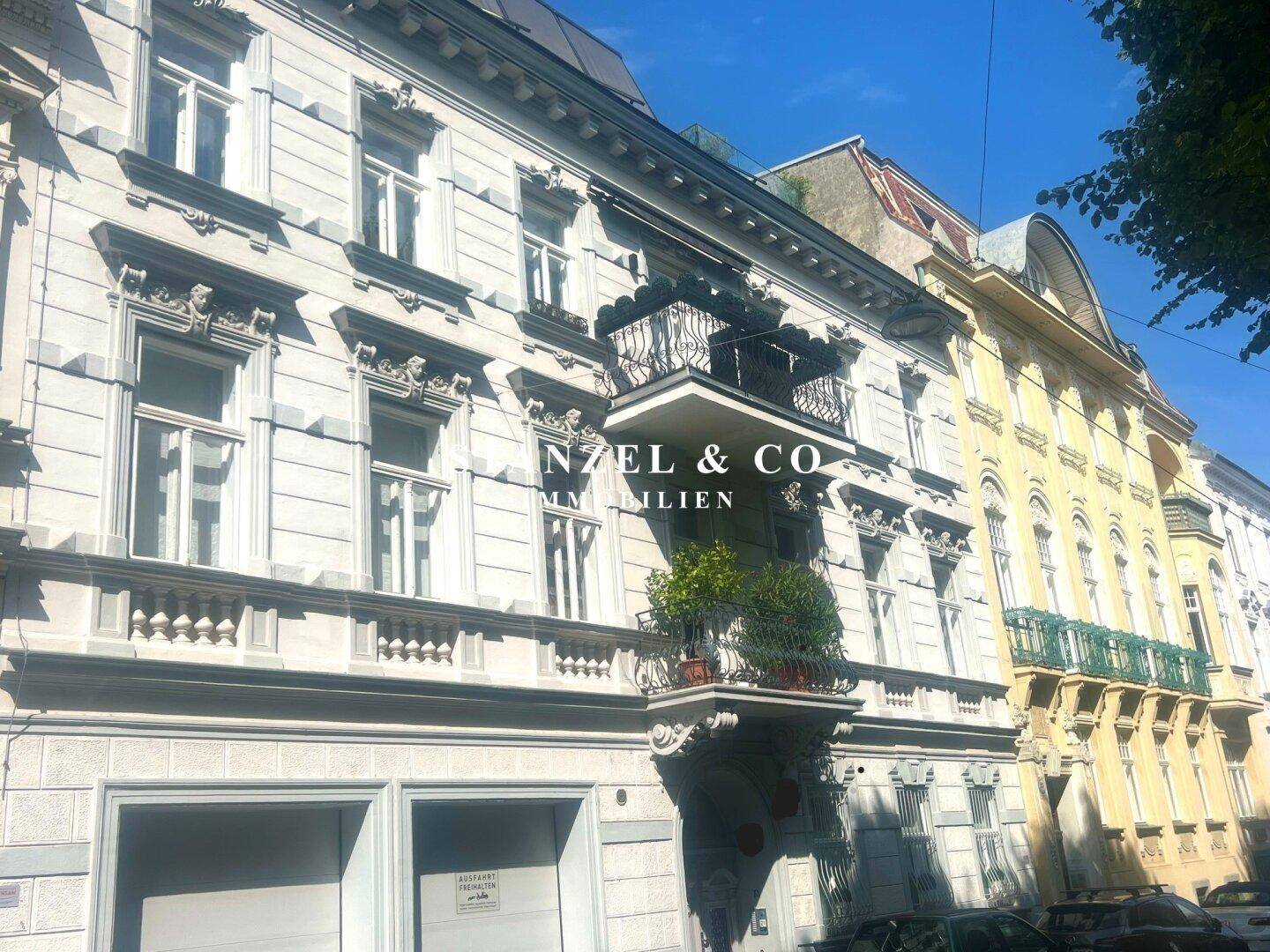 Klassische Architektur einer Stadtvilla mit verzierten Balkonen und großen Fenstern.