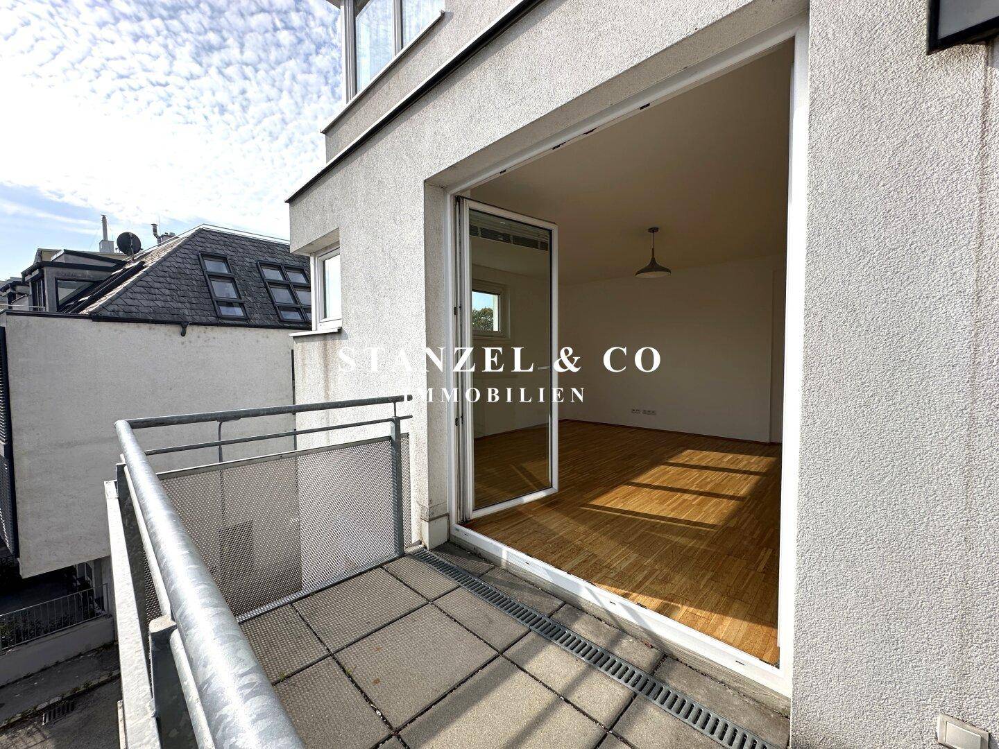 Heller Balkon mit Fliesenboden und direktem Zugang zu einem leeren Wohnraum, bietet viel Licht.