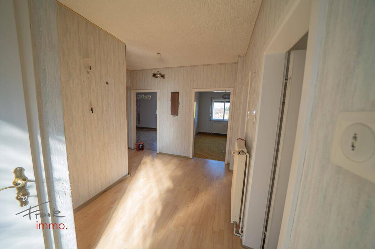 Heller Flur mit hellem Holzfußboden und Zugang zu mehreren Zimmern im Erdgeschoss.