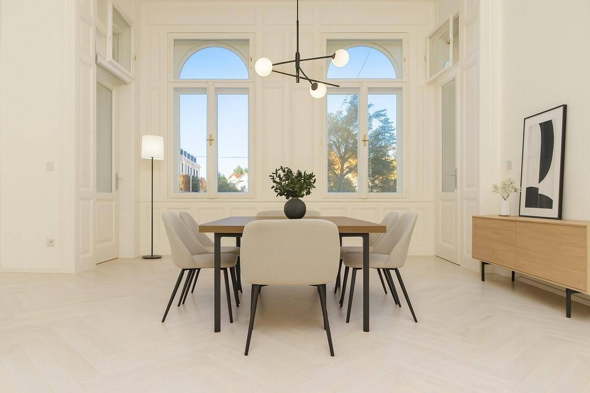 Eleganter Essbereich mit modernem Esstisch, Stühlen und stilvoller Beleuchtung vor großen Bogenfenstern.