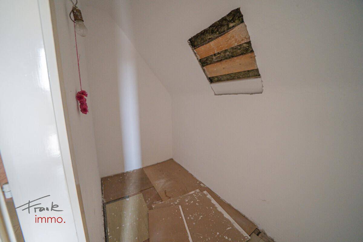 Kleiner, unfertiger Abstellraum mit einfacher Beleuchtung und sichtbaren Bauarbeiten.