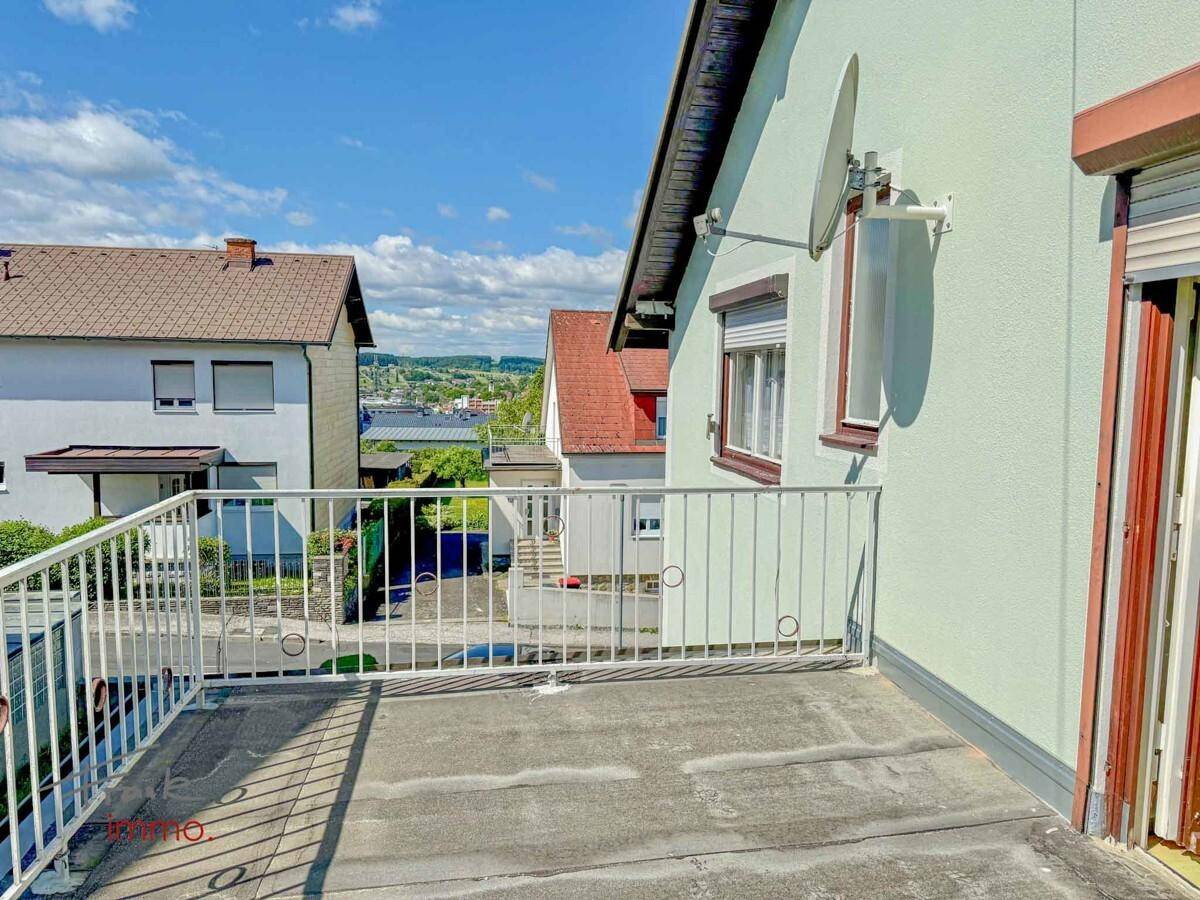 Balkon mit weitem Blick über die Landschaft und umliegende Häuser.