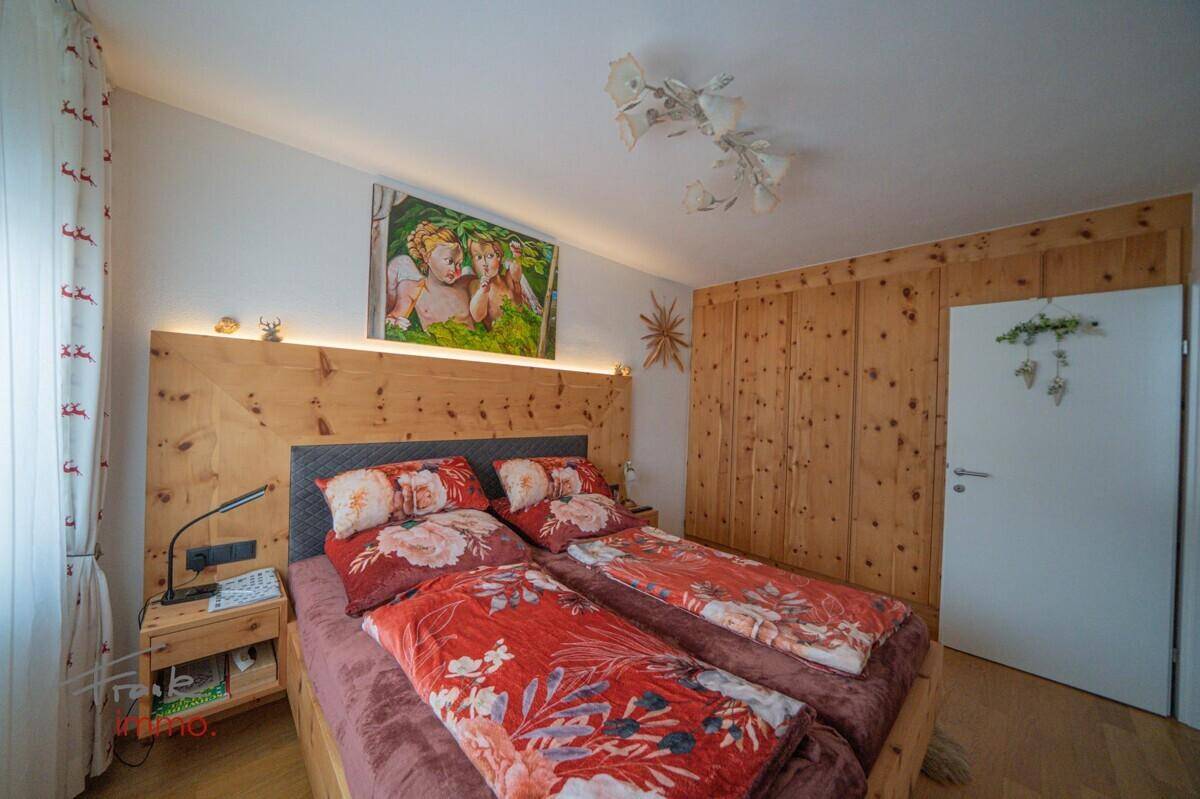 Schlafzimmer mit Holzbett, Holzwänden und Einbauschränken, gemütlich eingerichtet.