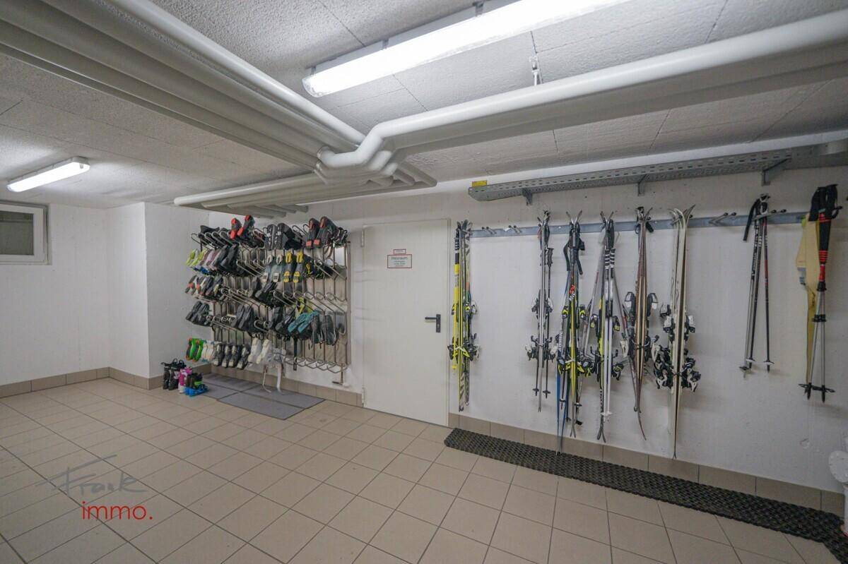 Praktischer Skiraum mit speziellen Halterungen für Skier und Skischuhe.