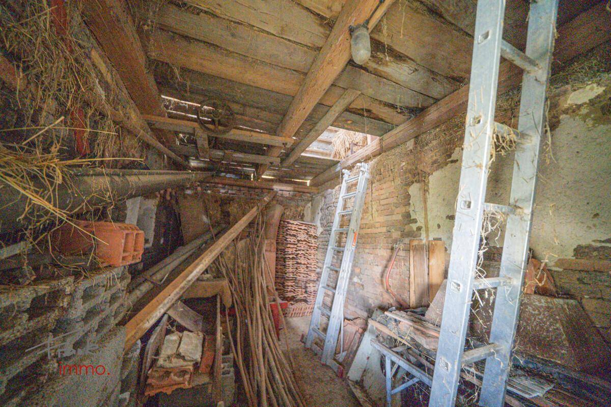 Alter Scheunenbereich mit Holzbalken und Lagerung von Materialien, im rustikalen Stil.