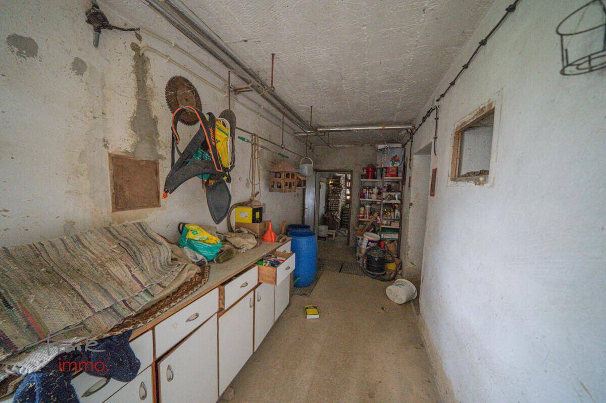 Geräumiger Werkstattbereich mit Arbeitsflächen und Lagerung, ideal für handwerkliche Tätigkeiten.