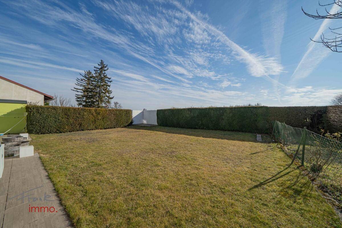 Gepflegter Gartenbereich mit Rasenfläche und Hecke unter weitem Himmel.