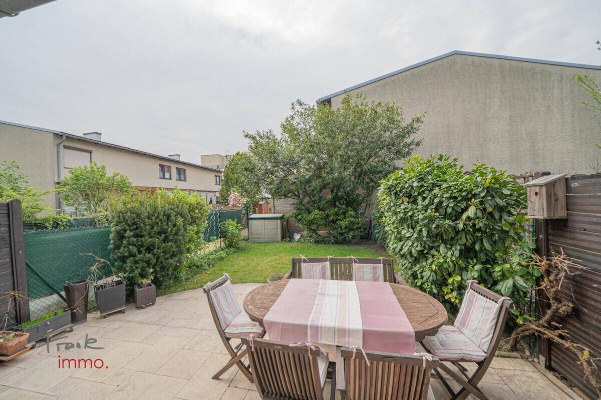 Gemütliche Terrasse mit Gartenmöbeln und Blick auf den grünen Gartenbereich.
