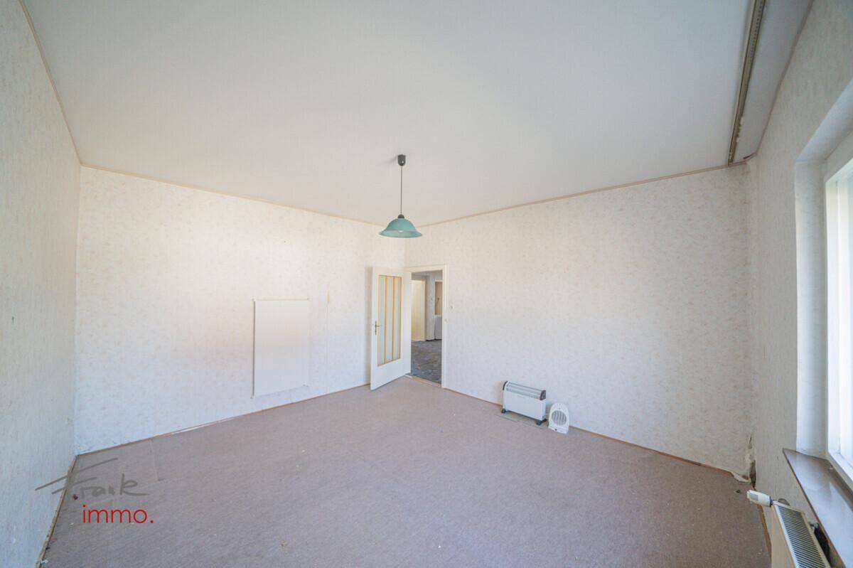 Heller Raum mit Teppichboden und Fenster, ideal für ein Wohn- oder Schlafzimmer nach Renovierung.