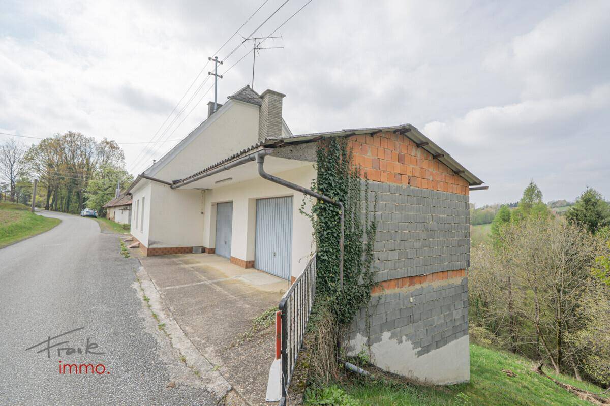 Garage mit angrenzendem Gebäude und ländlicher Umgebung, in solider Bauweise.