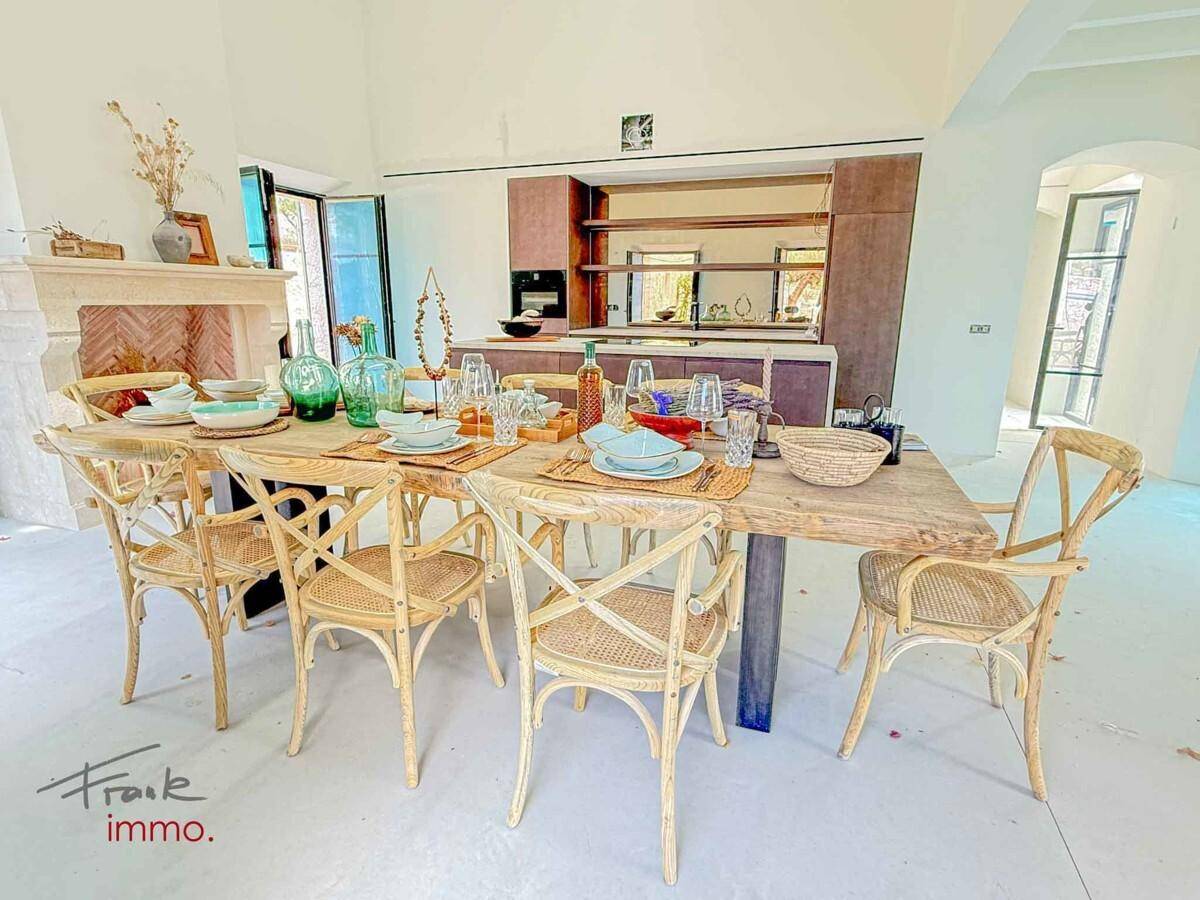 Festlich gedeckter Esstisch mit rustikalen Stühlen und einem eleganten Kamin im Hintergrund.