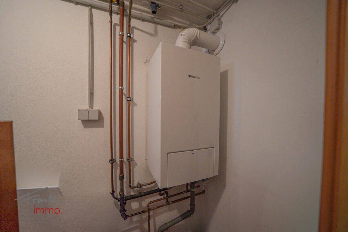 Moderne Heizungsanlage mit sichtbaren Rohren in einem separaten Technikraum.