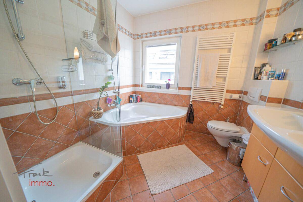 Funktionales Badezimmer mit Eckbadewanne, separater Dusche und beheiztem Handtuchhalter.