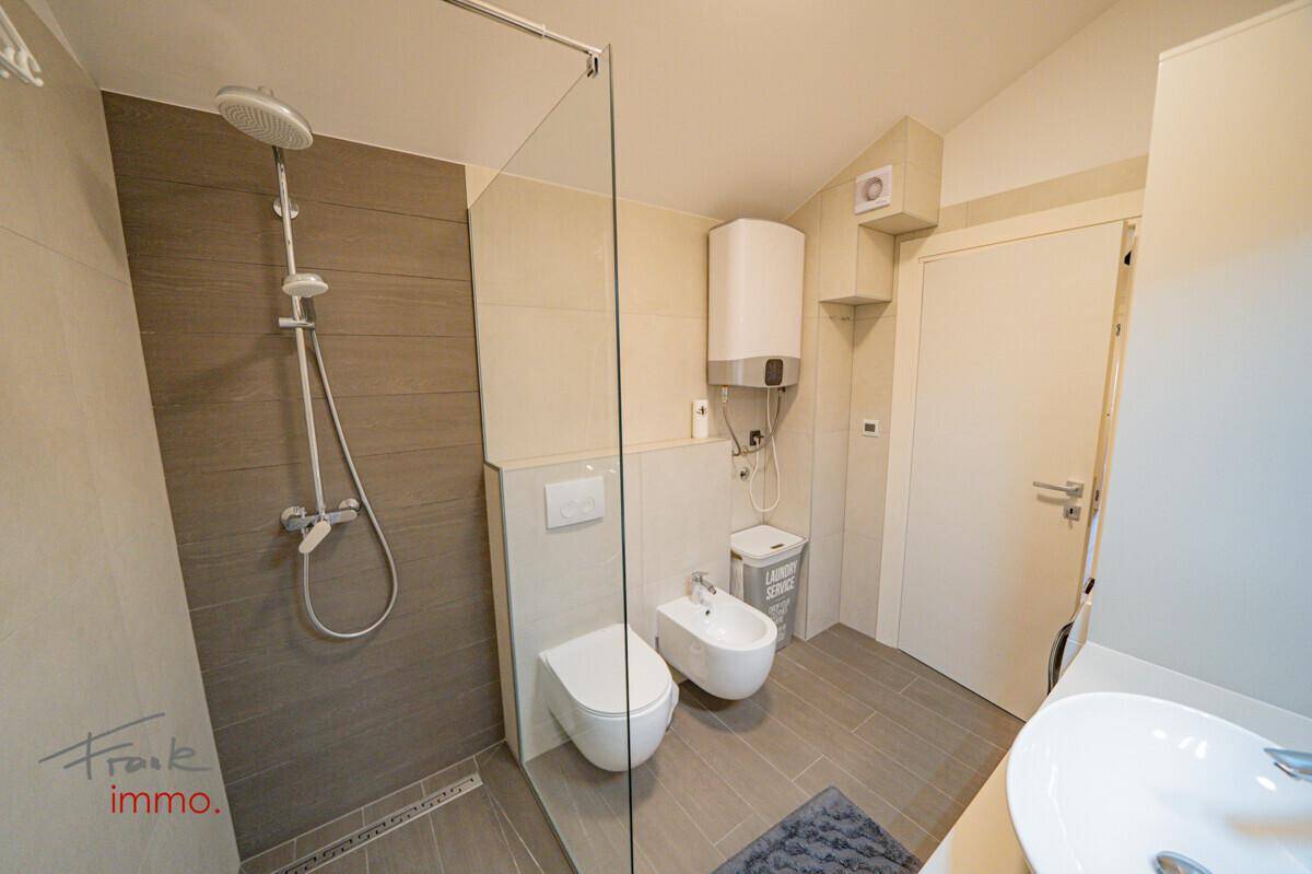 Modernes Badezimmer mit begehbarer Dusche, Bidet und Wand-WC.