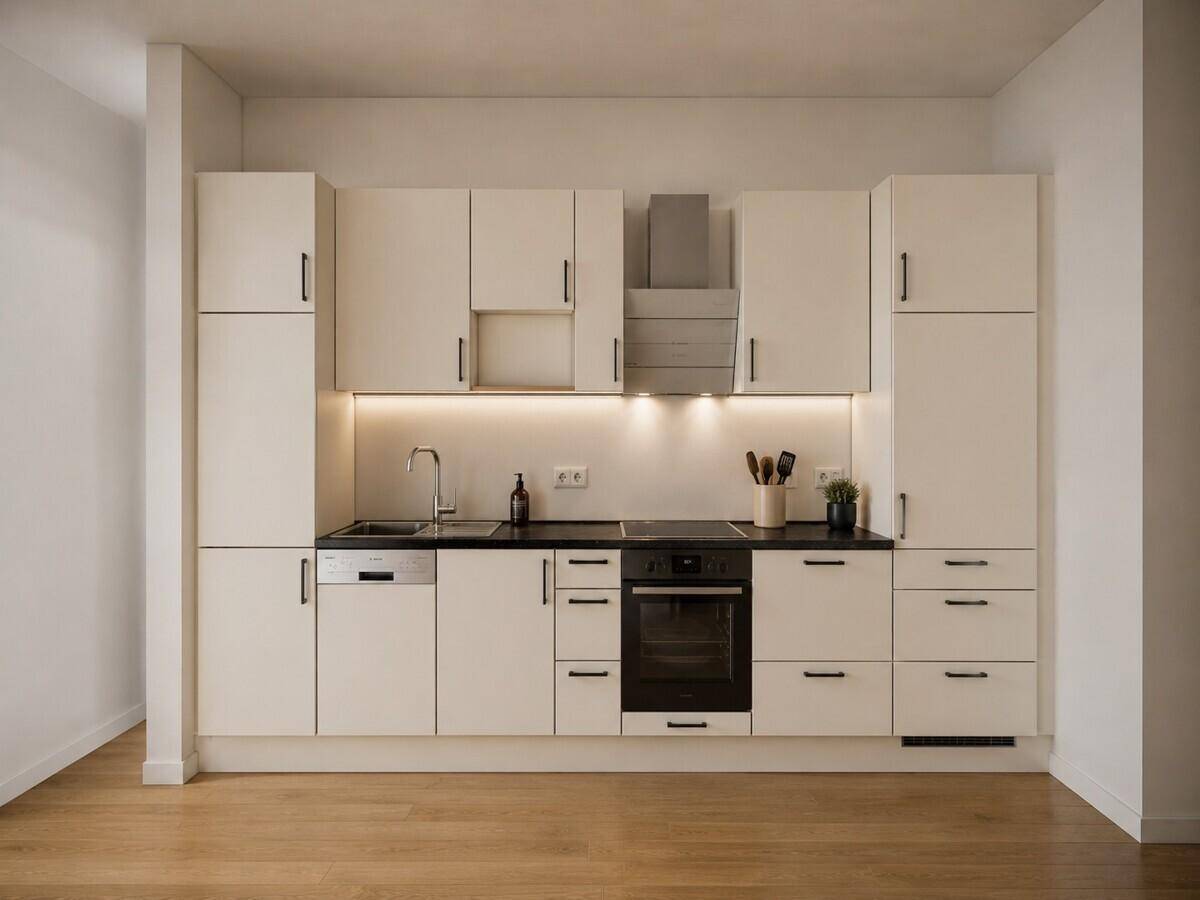 Moderne Einbauküche in hellem Design mit schwarzen Arbeitsplatten und integrierten Geräten.