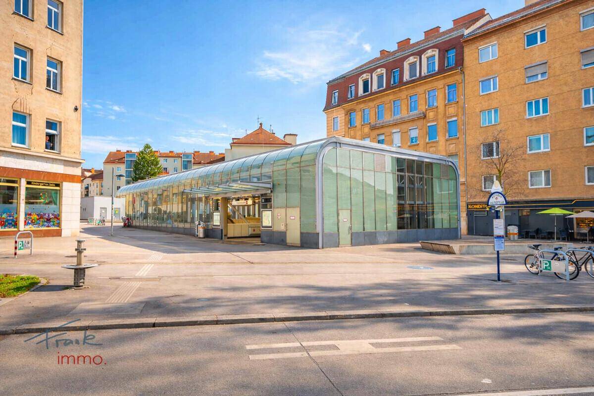 Moderner U-Bahn-Eingang mit Glasdach in einer städtischen Umgebung, gut zugänglich.