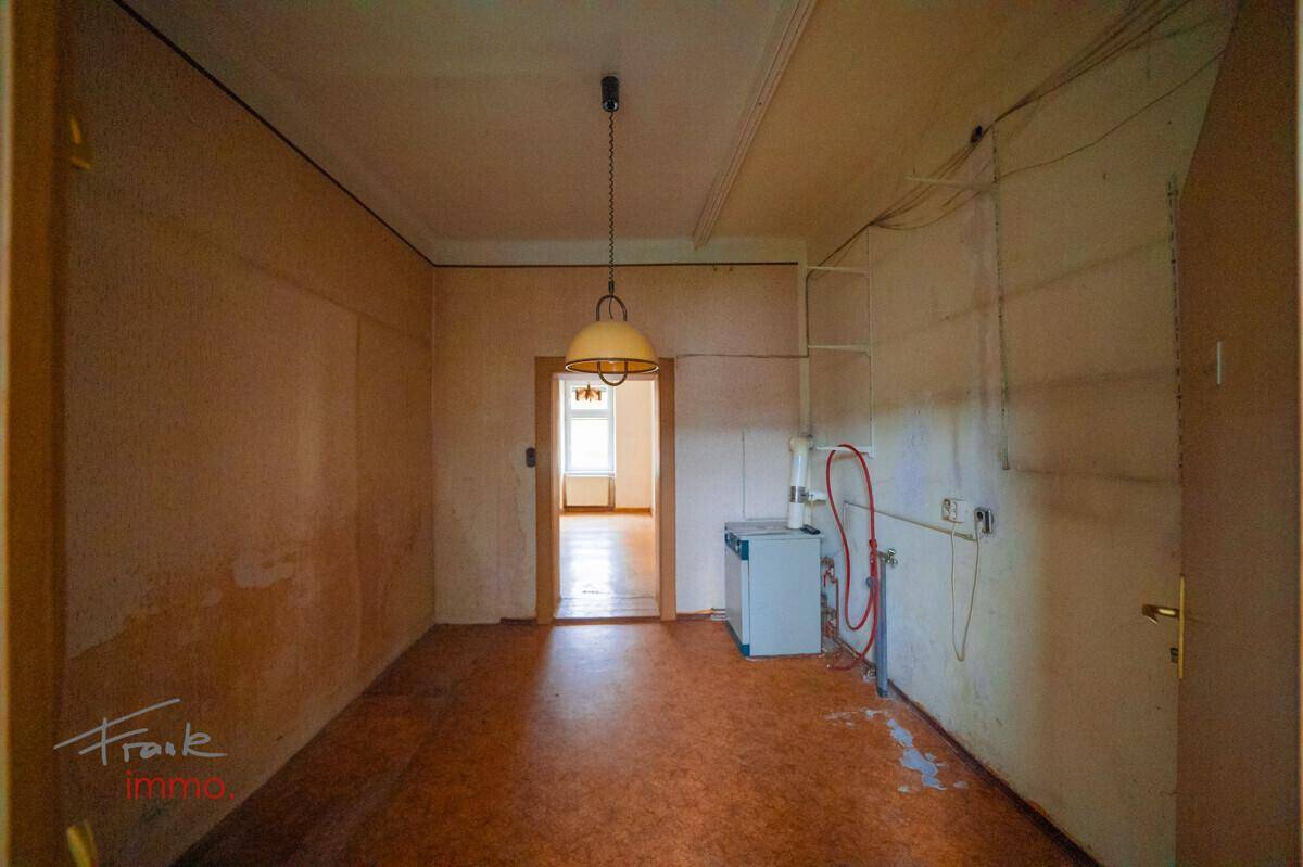 Funktionsraum mit Linoleumboden, Warmwasserbereiter und sichtbaren Installationen.
