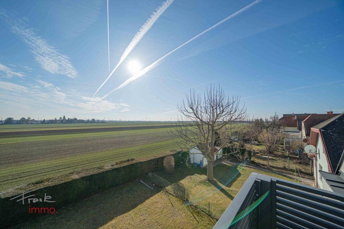 Weitläufiger Blick über Felder und Landschaft von einem Balkon.