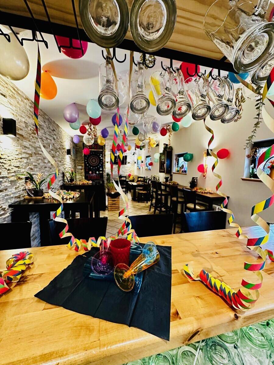 Festlich dekorierter Innenbereich einer Bar oder eines Restaurants mit Holztresen und Steinwand.