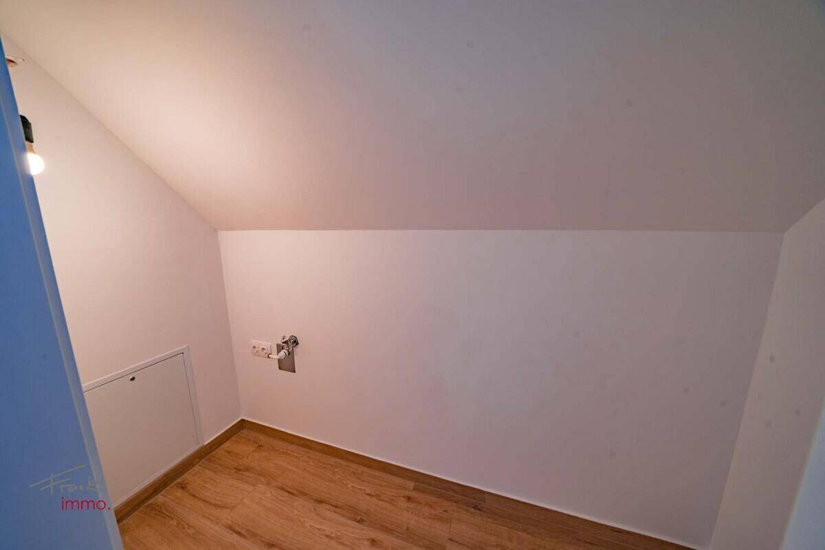 Leerer Raum mit Dachschräge und Holzoptikboden, ideal als Abstellraum oder kleines Zimmer.
