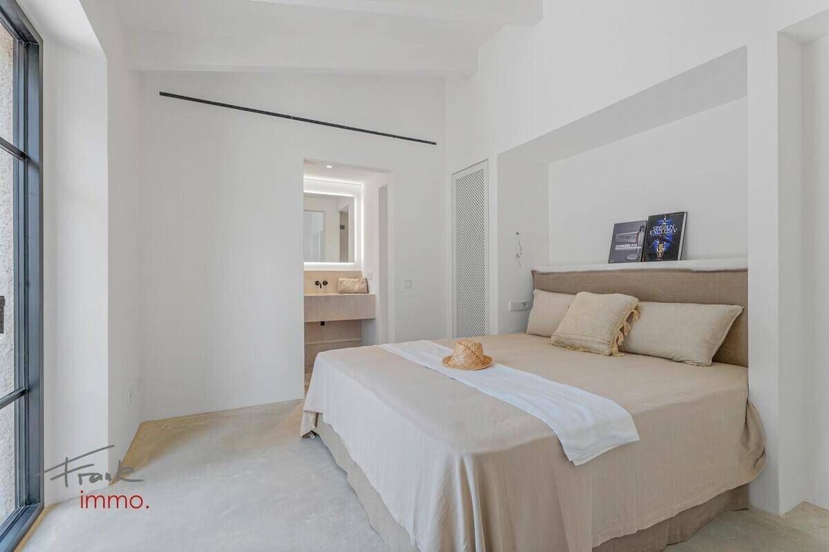 Ruhiges Schlafzimmer mit bequemen Bett und direktem Zugang zu einem modernen Badezimmer.