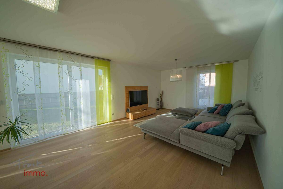 Gemütliches Wohnzimmer mit großem Sofa und Zugang zum Außenbereich.