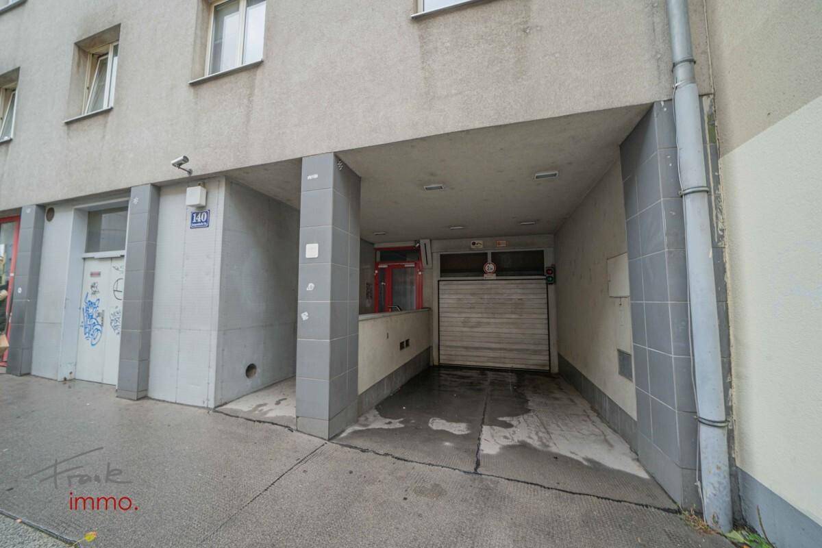 Gebäudeeingang mit Garagentor und einer Hausnummer, an der Straßenseite gelegen.