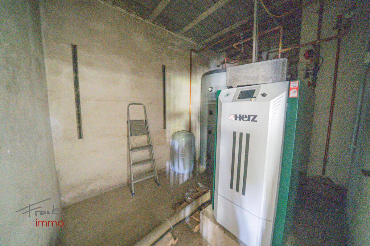 Heizraum mit modernem Heizsystem und Warmwasserspeicher, in gutem Zustand.