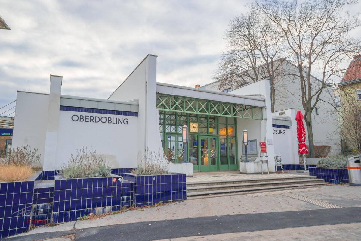Historisches Gebäude mit markanter Architektur und blauen Fliesen, das eine U-Bahn-Station beherbergt.
