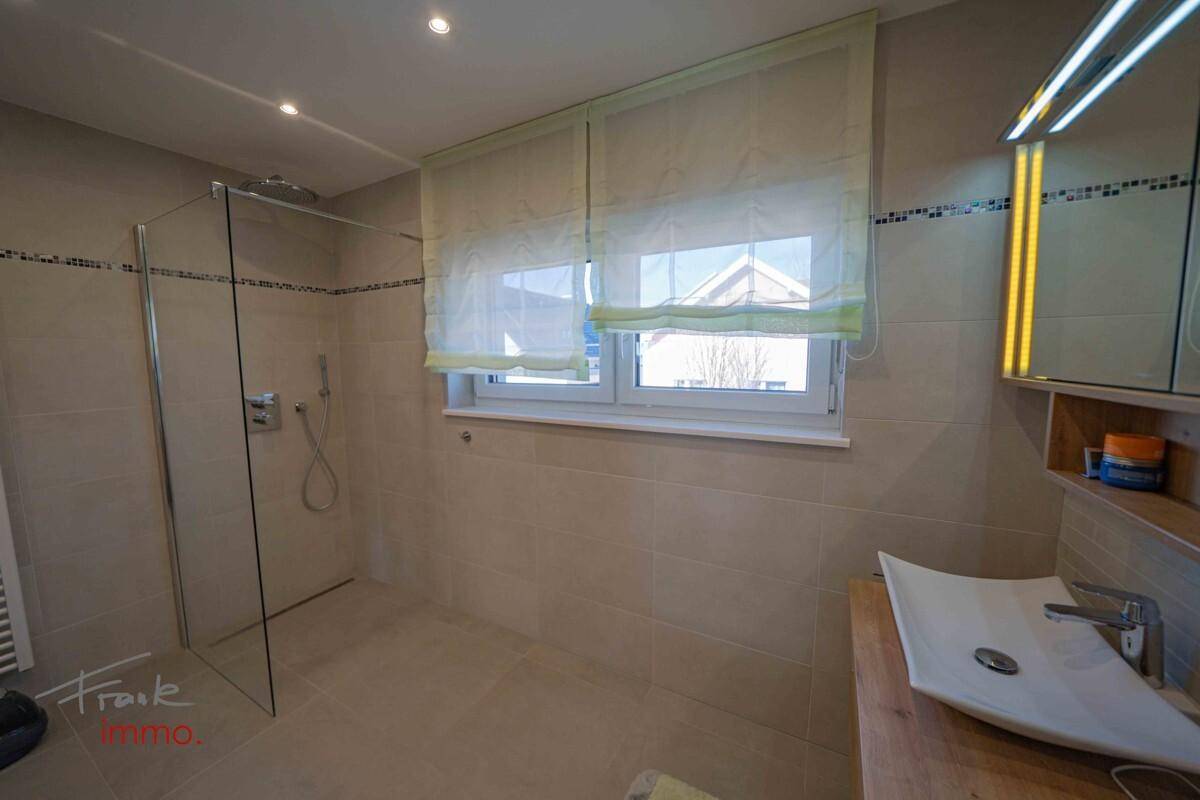 Modernes Badezimmer mit ebenerdiger Dusche, Einzelwaschbecken und Fenster.