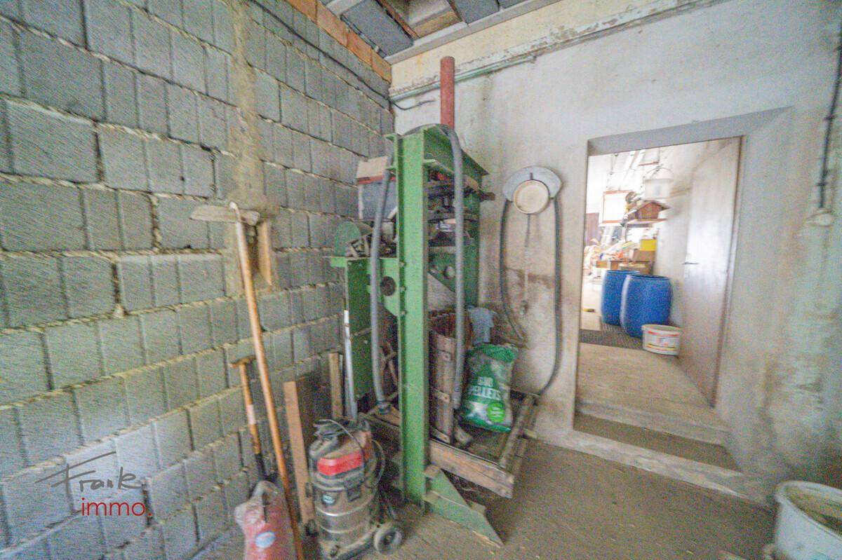 Kellerraum mit industrieller Maschine und Lagerfläche, ideal für Werkstatt oder Abstellraum.