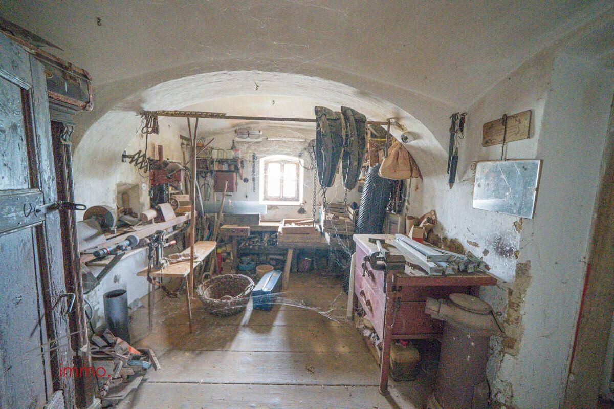 Werkstatt mit Werkzeugen, Arbeitsflächen und gewölbter Decke, im rustikalen Stil.