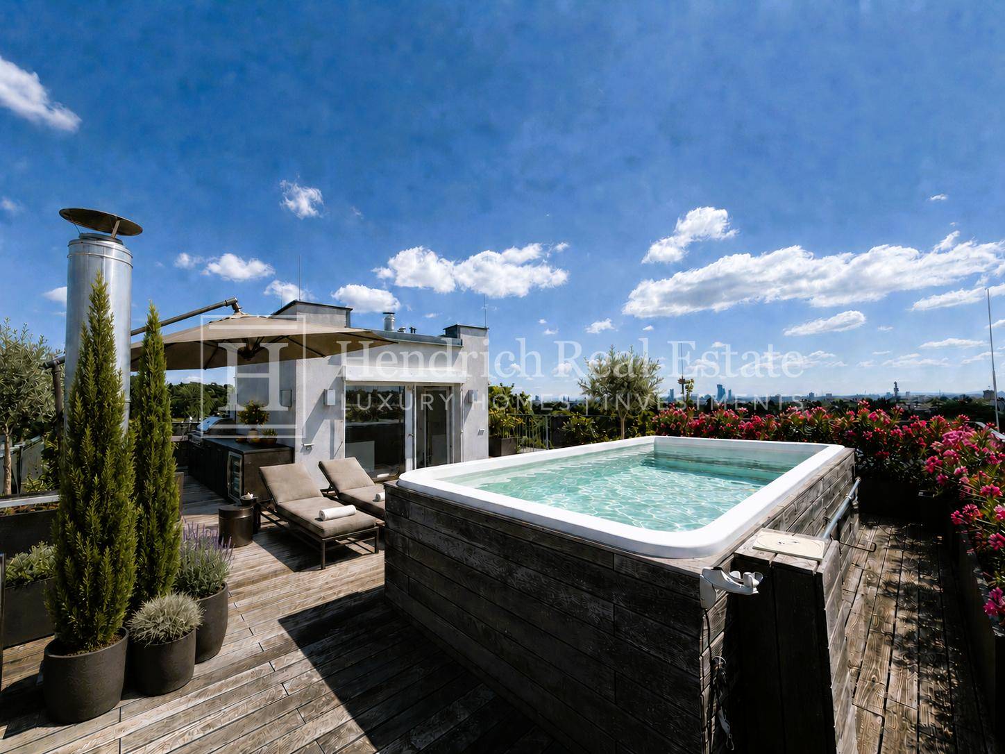 Exklusive Dachterrasse mit Pool, Liegestühlen und Panoramablick über die Stadt.