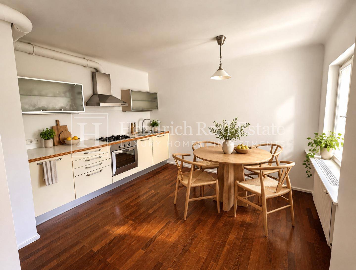 Moderne Einbauküche mit Essbereich, Holzboden und viel Tageslicht, ideal für gemeinsame Mahlzeiten.