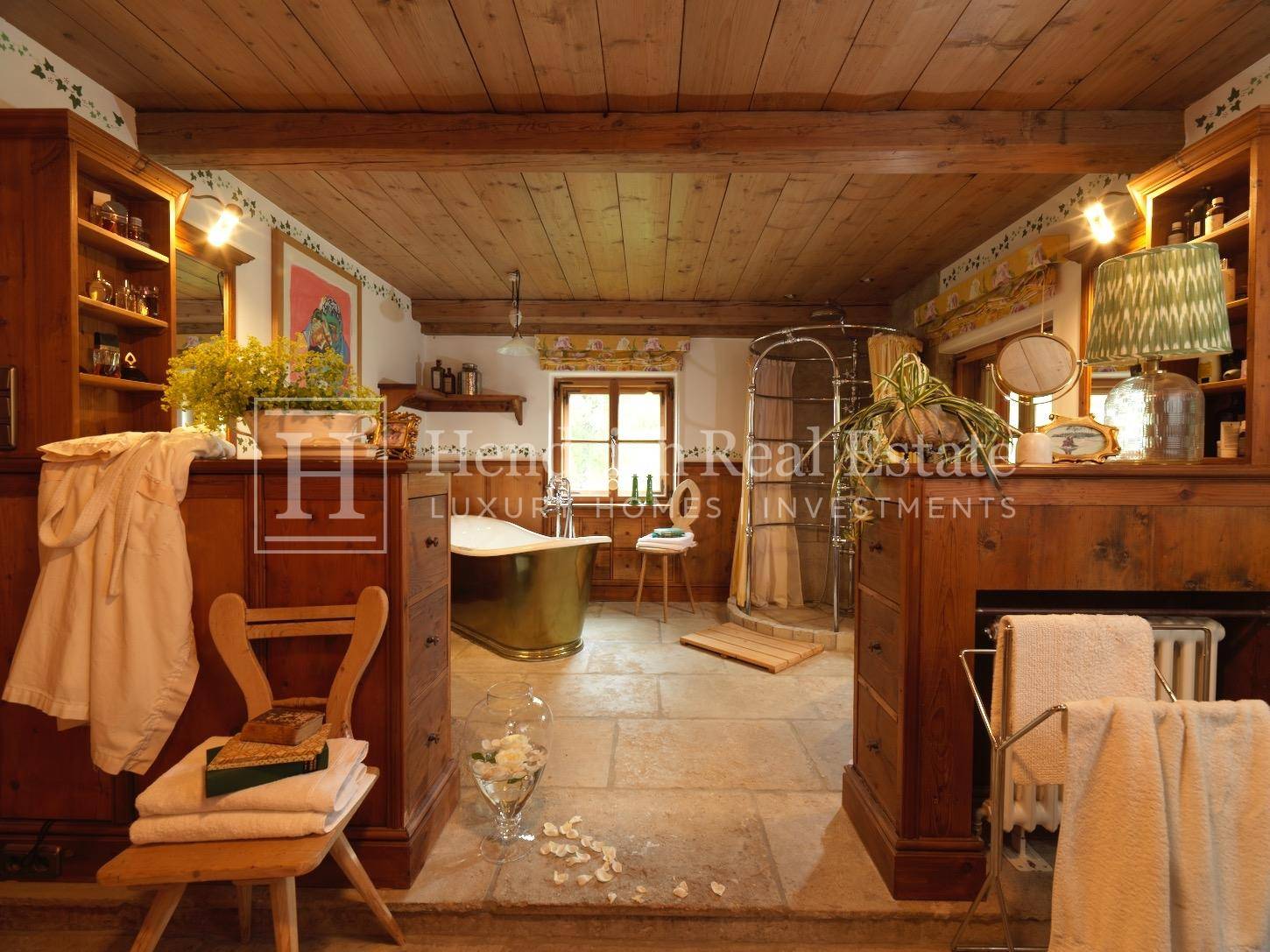 Geräumiges Badezimmer mit freistehender Badewanne, Dusche und Natursteinboden.