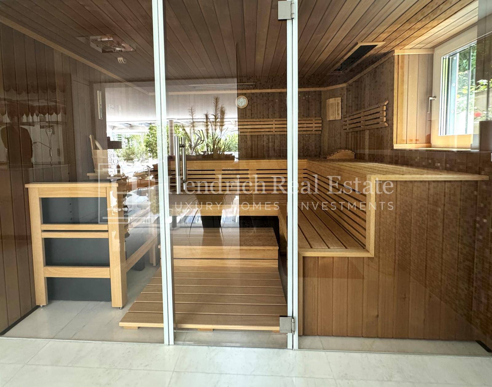 Moderne Holzsauna mit Glasfront und bequemen Bänken, ideal zur Entspannung.