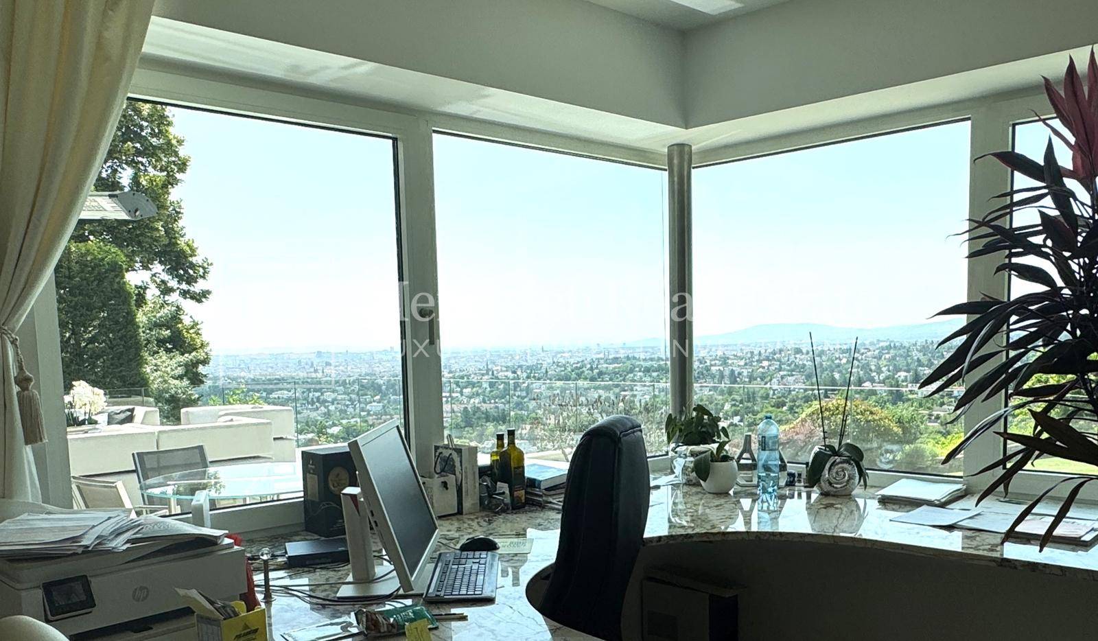 Helles Büro mit großen Fenstern, die einen weiten Panoramablick über die Stadt und die Landschaft bieten.