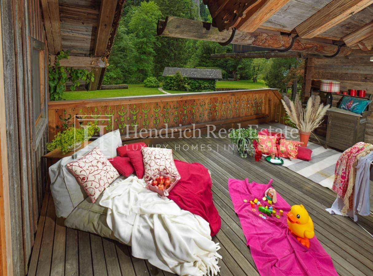 Geräumiger Holzbalkon mit Sitzgelegenheiten und Blick ins Grüne.