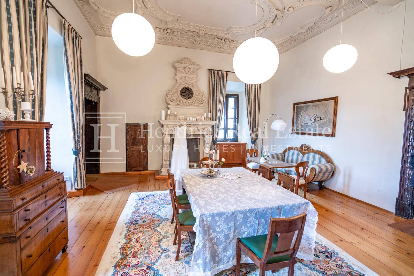 Eleganter Speisesaal mit kunstvollem Kamin, Stuckdecke und Holzboden, eingerichtet im traditionellen Stil.