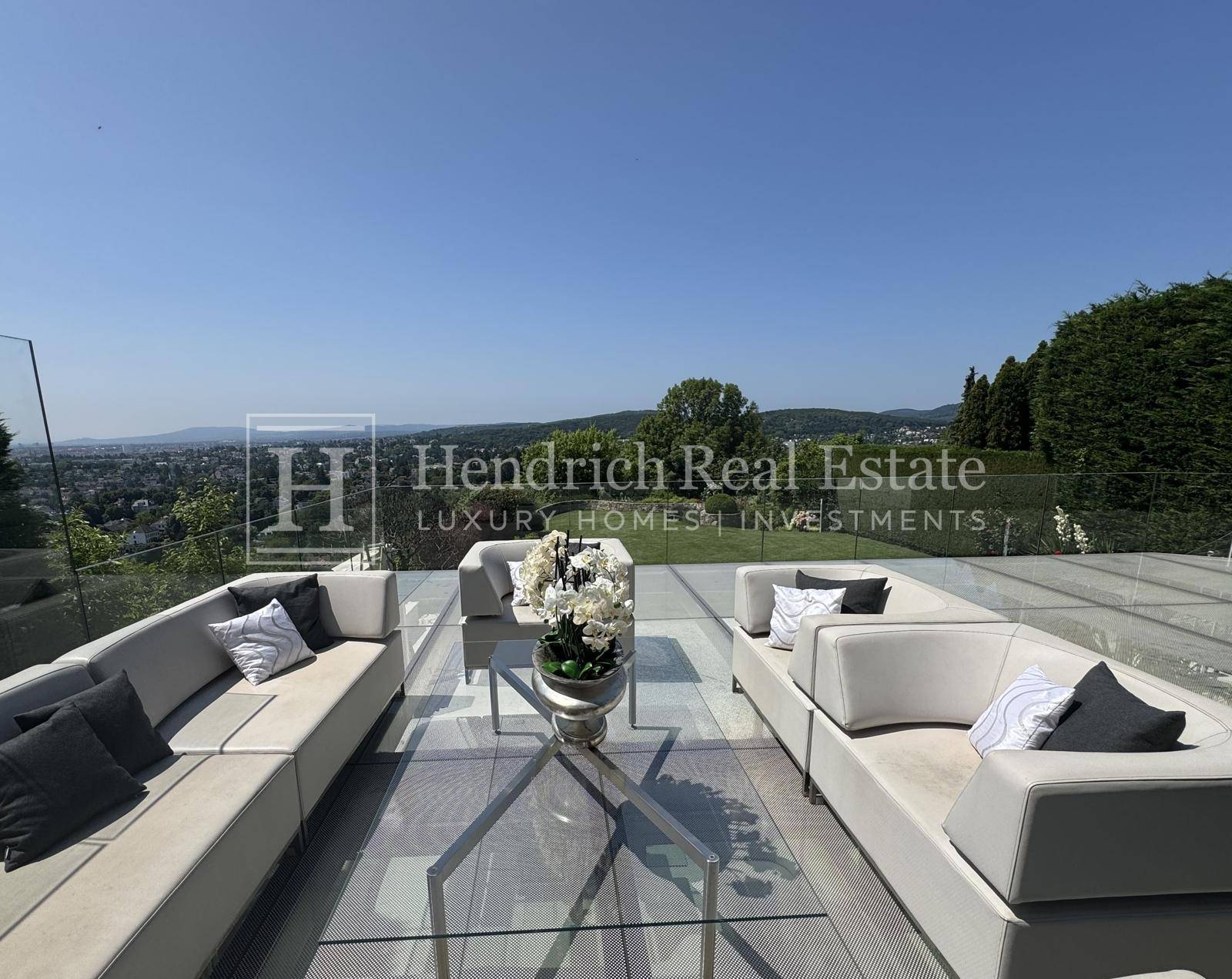 Elegante Terrasse mit modernen Loungemöbeln und weitem Blick über die Landschaft.