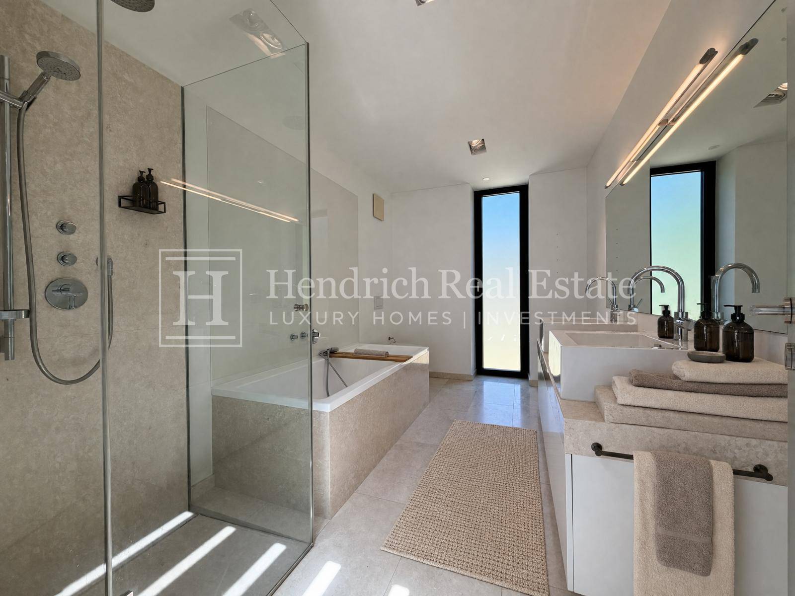 Geräumiges Badezimmer mit moderner Duschkabine, Badewanne und Doppelwaschbecken.