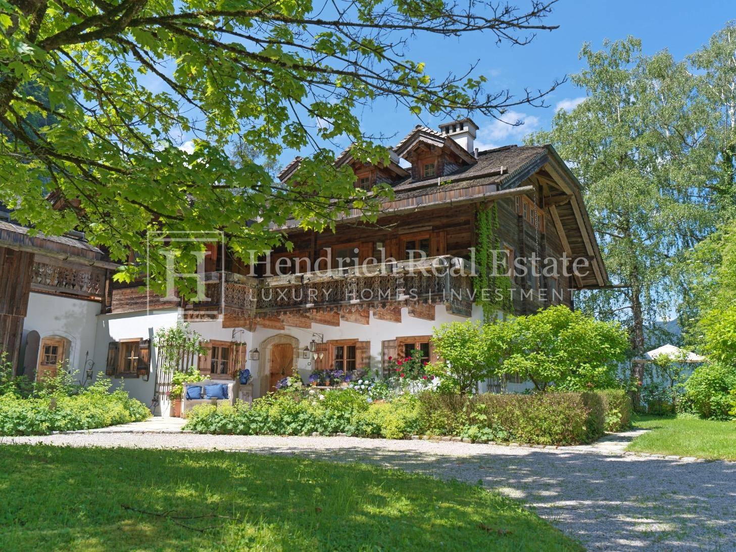 Traditionelles alpenländisches Haus mit charmantem Garten und üppiger Vegetation.