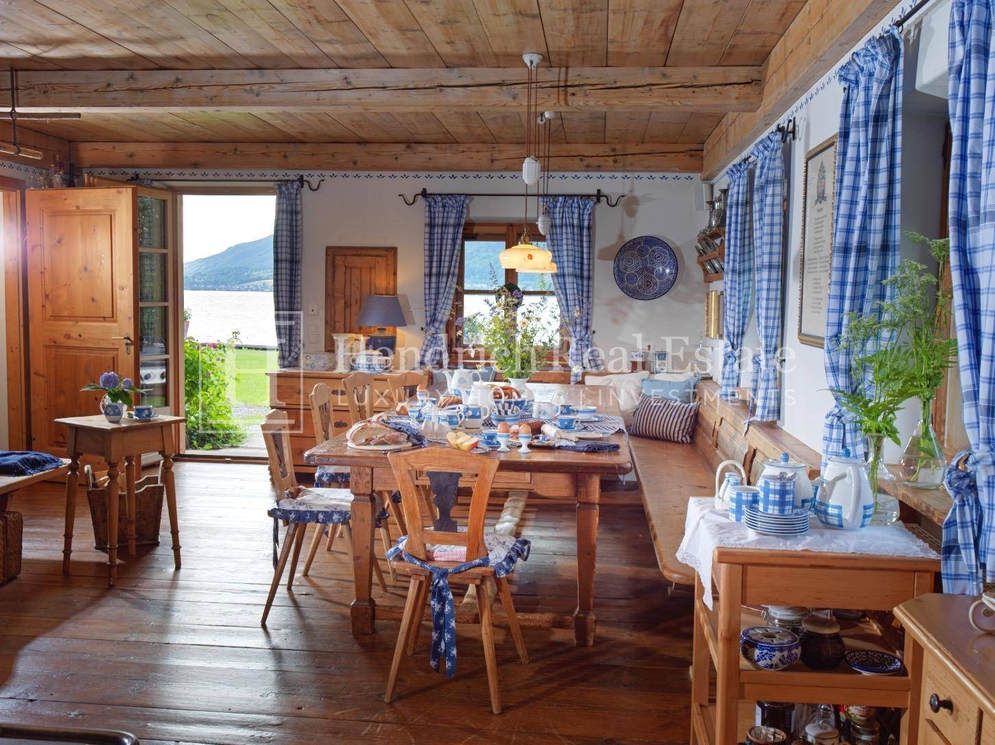 Gemütlicher Essbereich im Landhausstil mit Holzbalken und Blick auf den See.