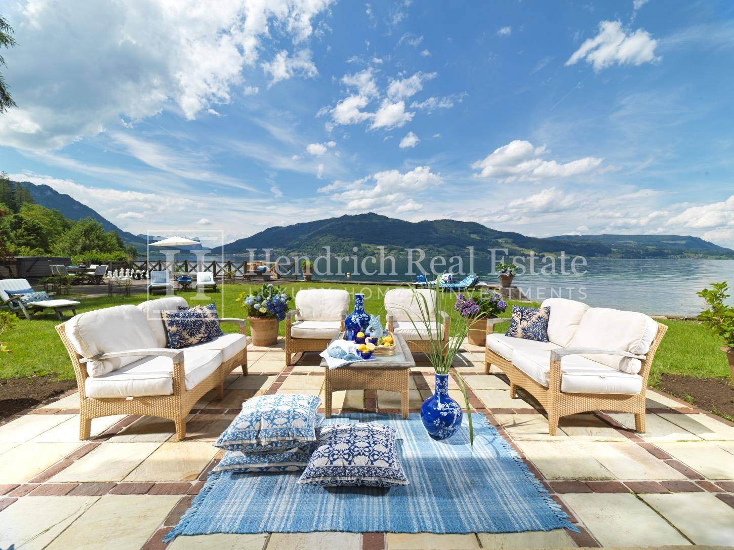 Geräumige Terrasse mit bequemen Gartenmöbeln und weitem Blick auf den See und die Berge.