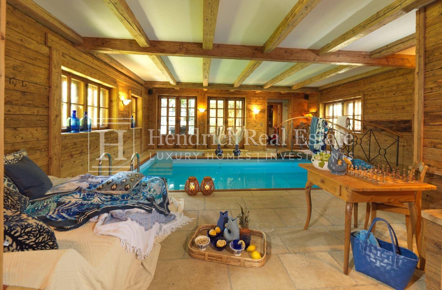Exklusiver Innenpoolbereich mit Holzverkleidung und gemütlicher Liegefläche.