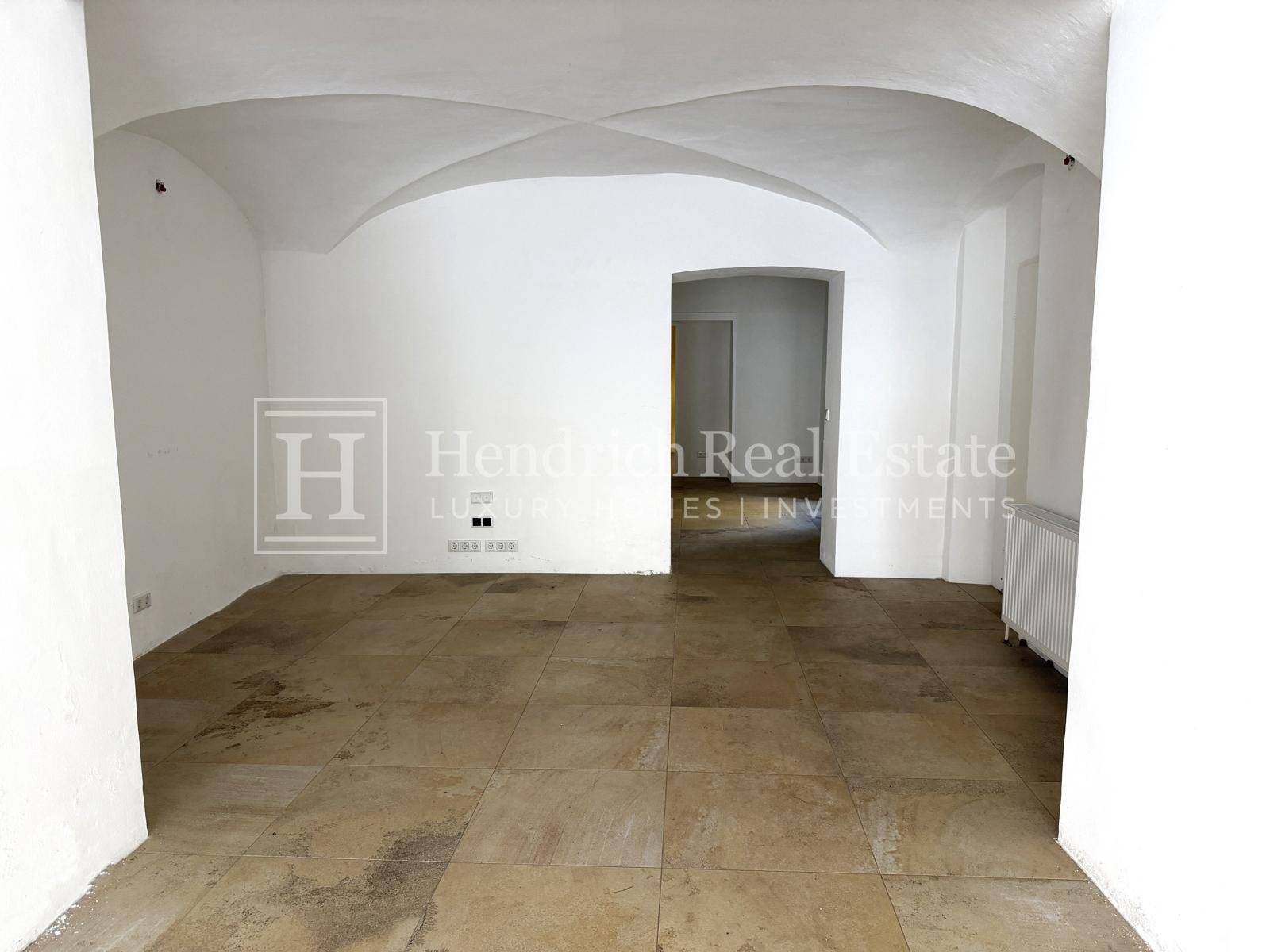 Heller, offener Wohnbereich mit Fliesenboden und charakteristischen Gewölbedecken, ideal für verschiedene Nutzungen.