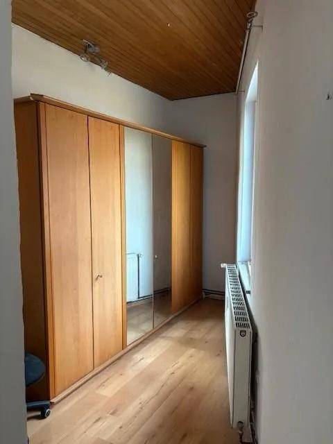 Raum mit großem Holzschrank mit Spiegeltüren, Holzboden und Holzdecke.