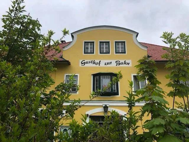Nahaufnahme der gelben Fassade eines Gebäudes mit "Gasthof zur Bahn" Schriftzug.