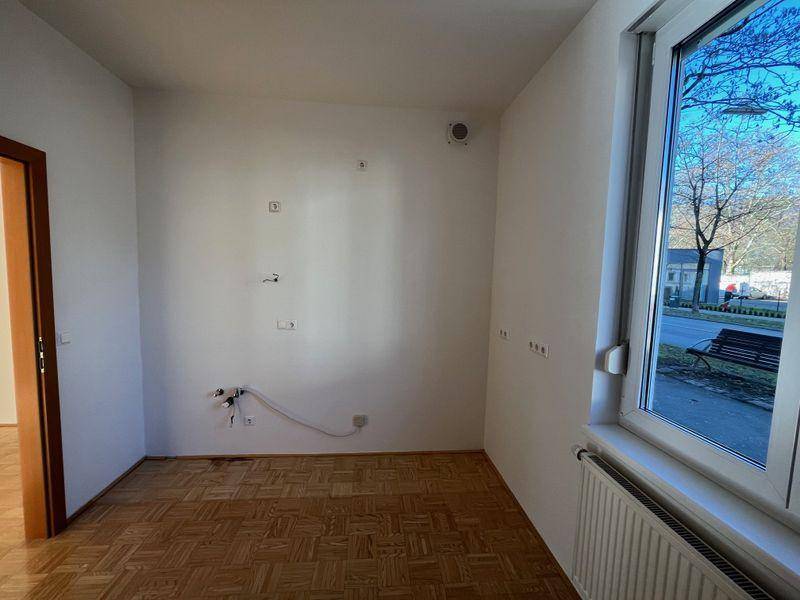 Heller Küchenraum mit Fenster und Anschlüssen für die Installation einer modernen Küche.